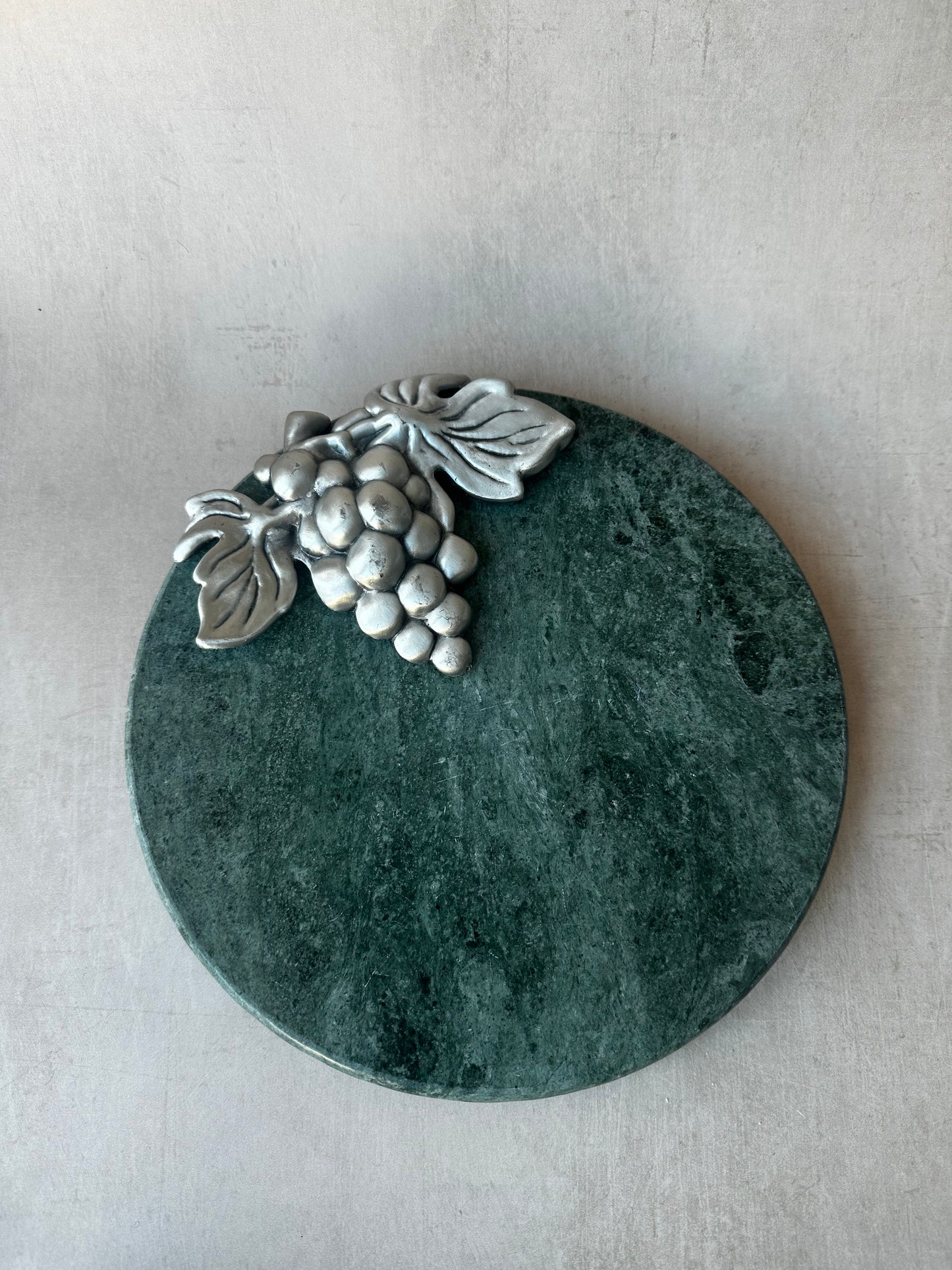 Plateau de fromages en marbre vert avec raisins