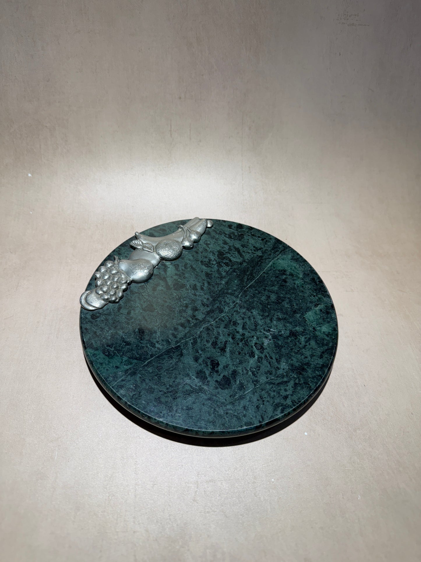 Plateau de fromages en marbre vert avec fruits argentés