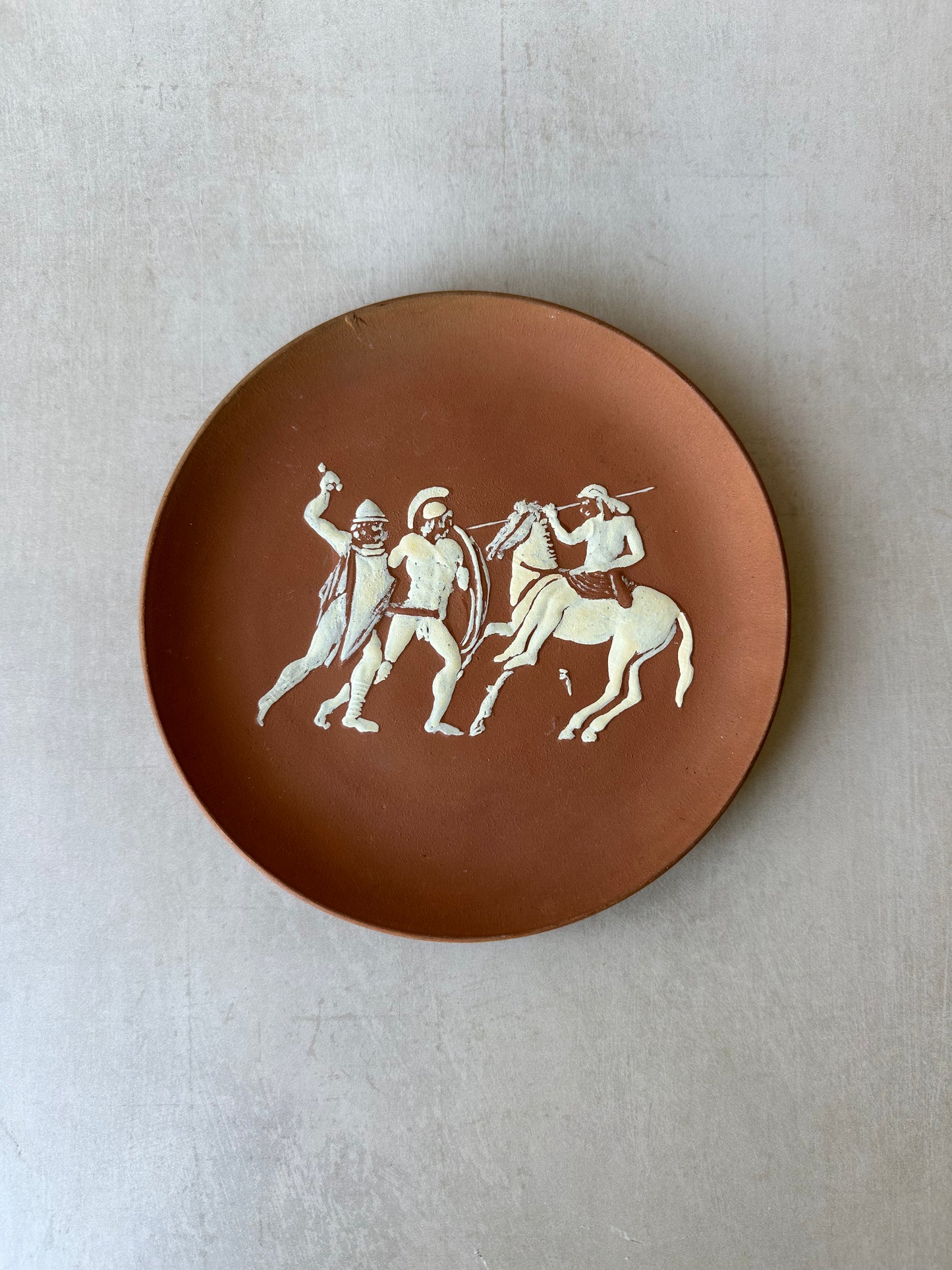 Plat mural en terre cuite représentant un cheval de Troie